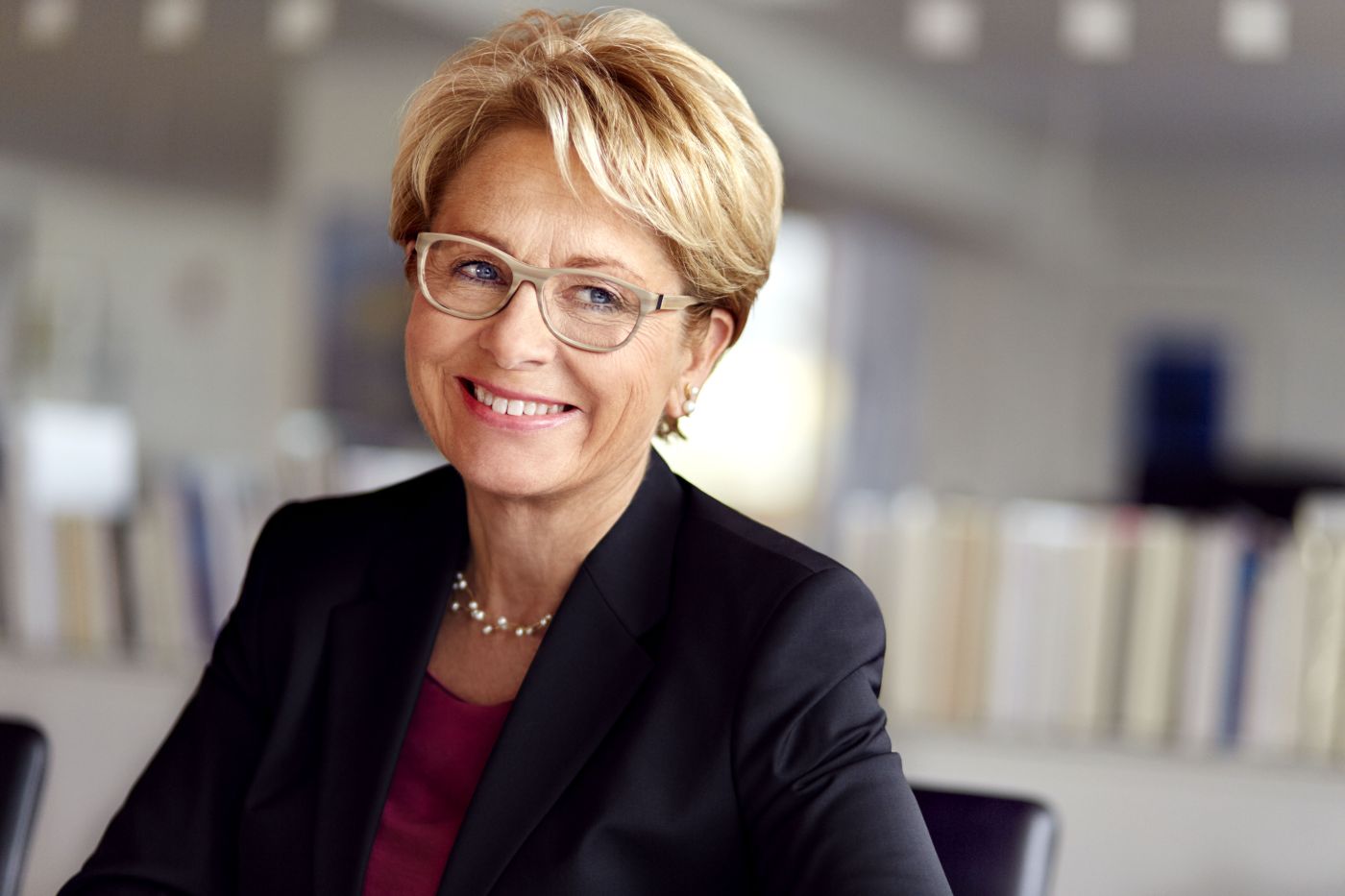 Corporate Fotograf Berlin: Businessportrait einer Managerin im dunklen Blazer im Büro